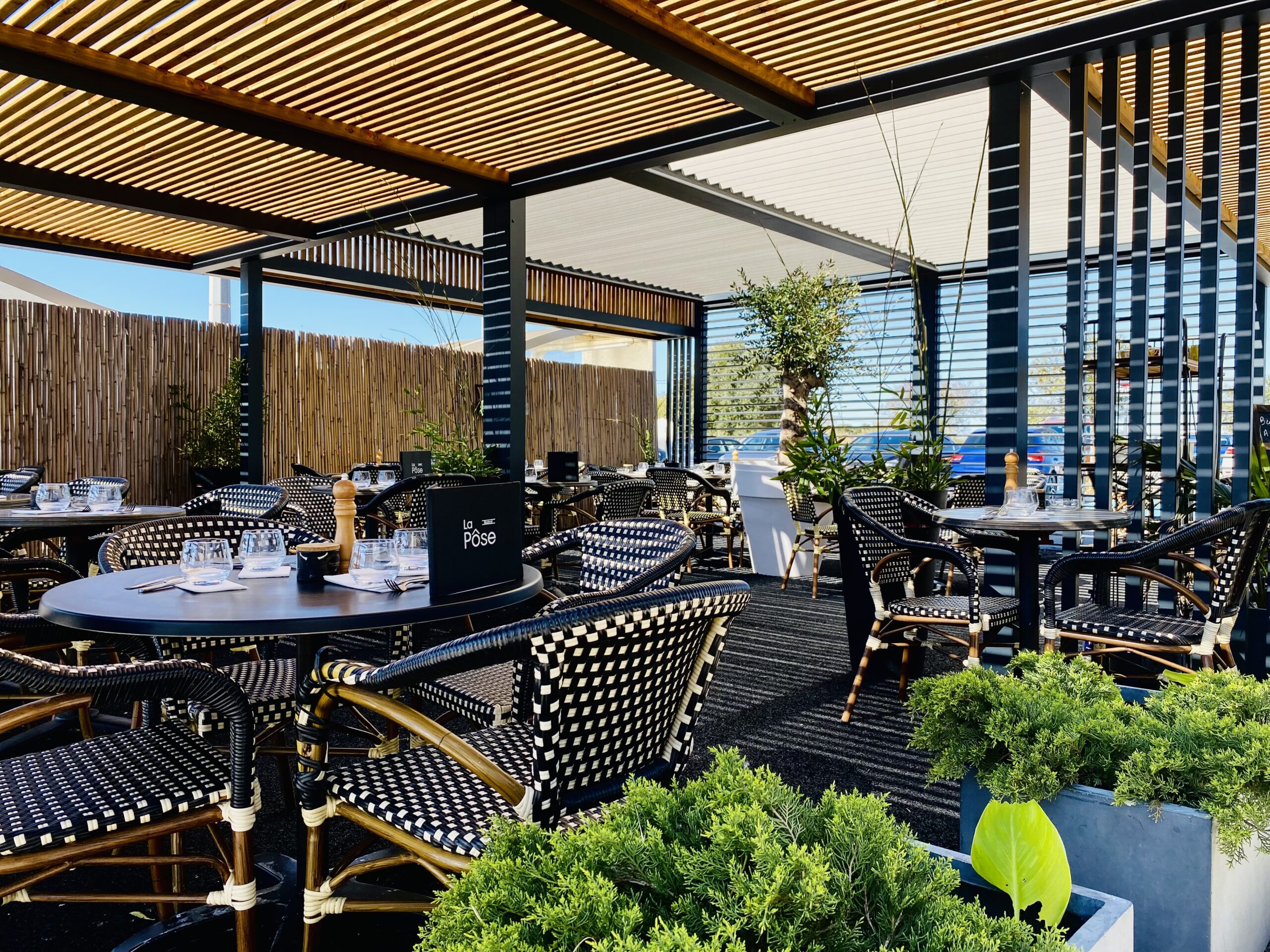 Terrasse couverte du bistrot La Pôse Aigues-Mortes — pergola, chaises de bistrot, plein air et parking gratuit route de Nîmes